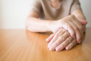 personne âgée dont la main tremble à cause de Parkinson